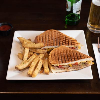 Beef, cheese and veggie sandwich with a side of fries.
