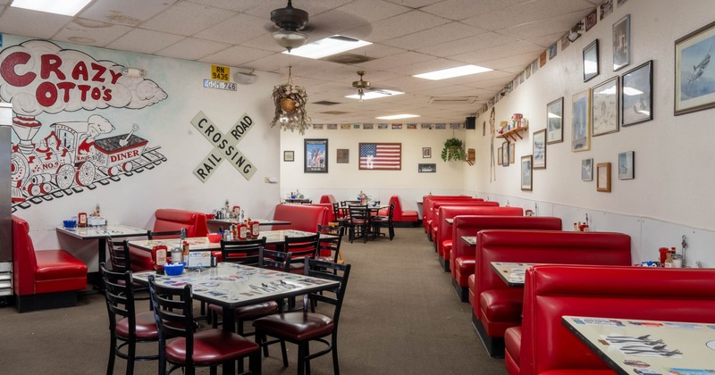 Interior, vintage-style diner with red booths, eclectic wall decor including a mural