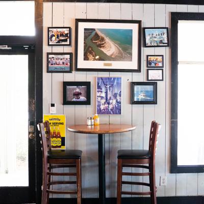Dining table, framed pictures on the wall.