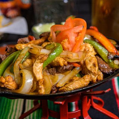Fajitas with beef, chicken, peppers, and onions.