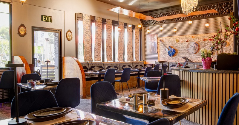 Interior dining area with traditional design elements, elegant blue velvet chairs and set tables