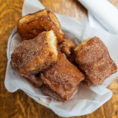 Cinnamon Rolls served in a basket lined with paper.
