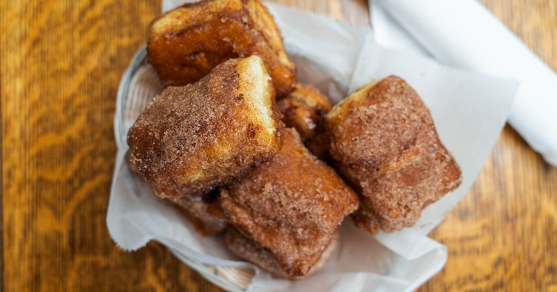 Basket of cinnamon rolls served on a wooden table