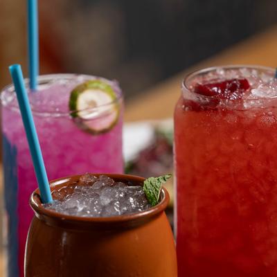 A close-up of three vibrant cocktails.