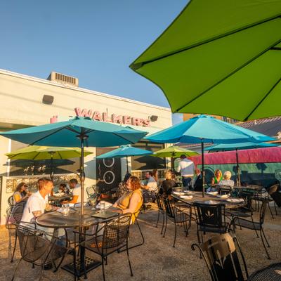 Guests sitting under colorful umbrellas in an outdoor seating area.