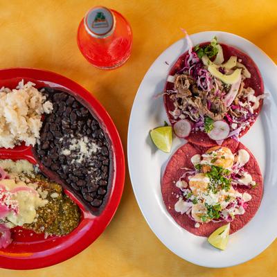 Taco plate, a plate of enchilada served with rice and beans, Mexican soda bottles.