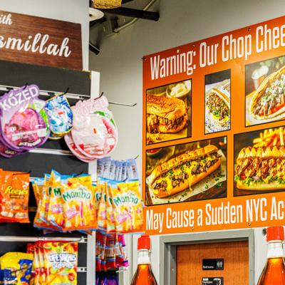 A wall display with menu pictures and snack packages.