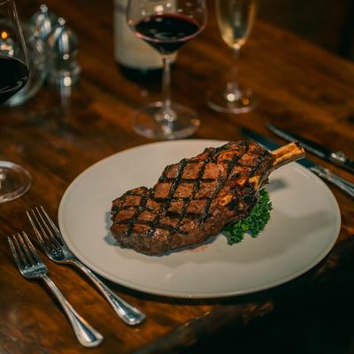 20 ounce Chicago Bone-In Rib eye served with wine.