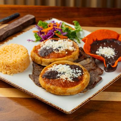 Sopes with beans and cheese served with rice, meat, and beans.