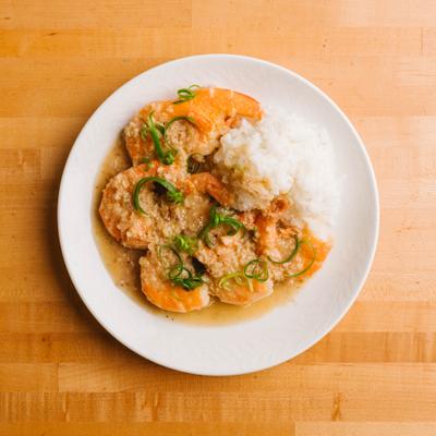 Garlic shrimp served over rice with sauce.