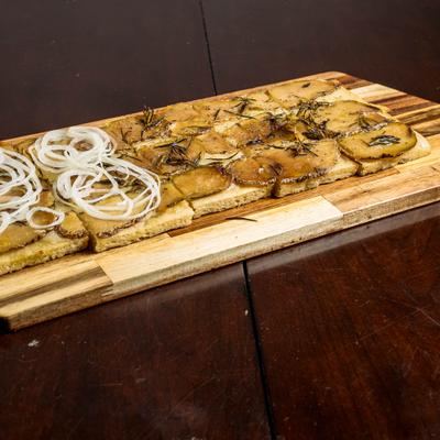 Roman-style potato pizza topped with onions and rosemary.