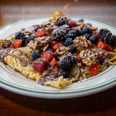 Nutella crepes topped with berries and powdered sugar.