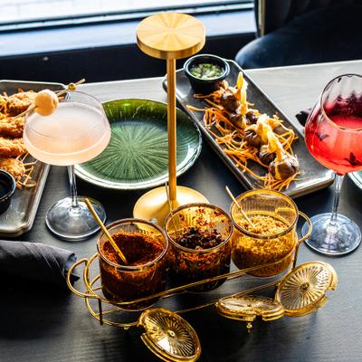 Cocktails served with skewers and spices on a gray table.