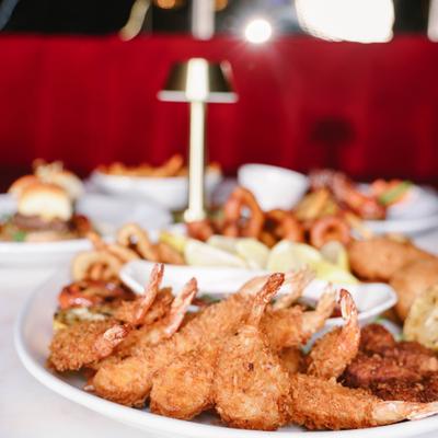 Fried shrimp platter served with dipping sauce and sides.