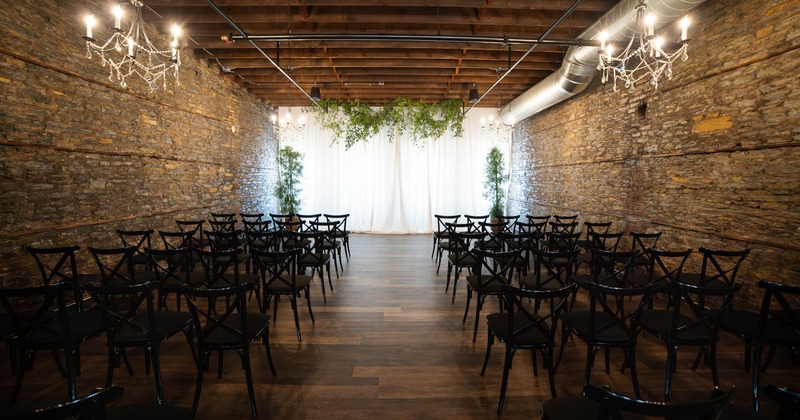 A rustic event space with stone walls and a white curtain at the back