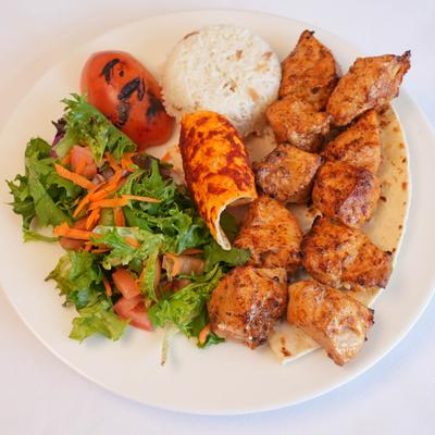 Two chicken shish kebabs served with a green salad and rice.