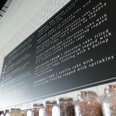 Interior, information board with descriptions of various cupcakes.