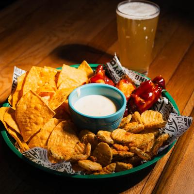 BBQ chicken wings, tortilla chips, fried pickles, cheese dip, and beer.