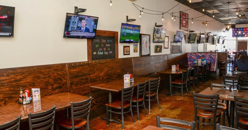 Interior, tables and chairs lined up, tv screens on the wall