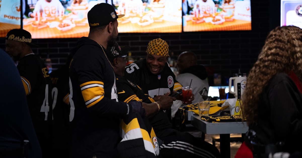 Bar area, guests, tv screens behind