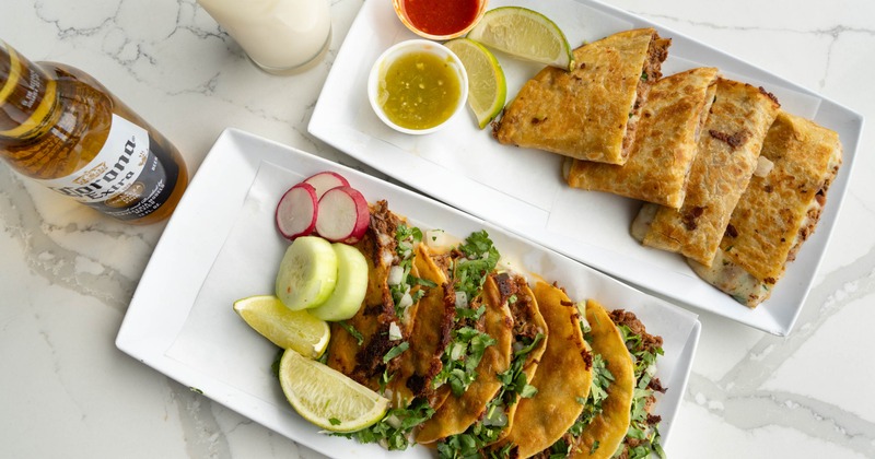 Chicken quesadilla and deep fried pork taco plates served with a bottle of beer