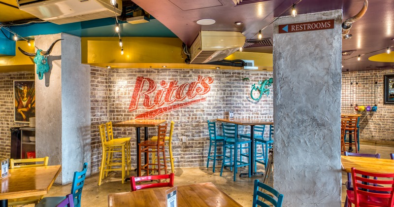 Interior, tables, chairs, restaurant logo on a brick wall