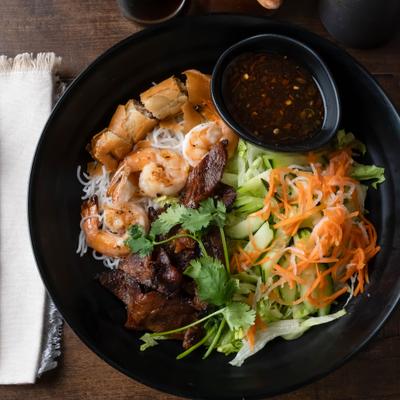Vermicelli pork and shrimp noodle bowl with sauce on the side.