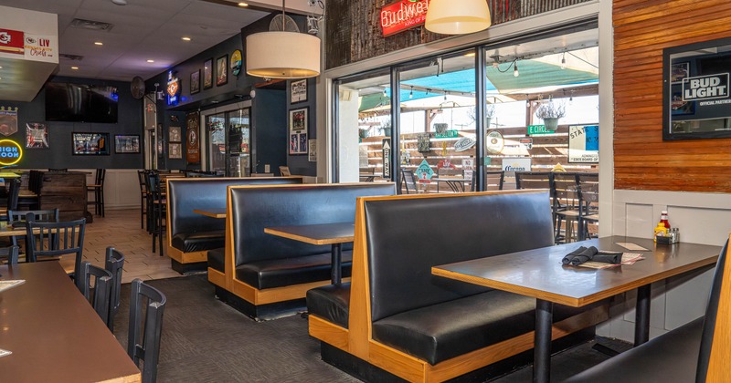 Interior with booths, tables, decor and a view to the patio