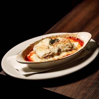 Beef Lasagne served in oval baking dish, garnished with dried herbs.
