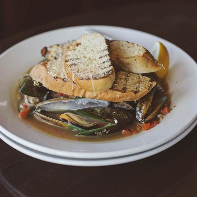 Mussels in plate with bread on top