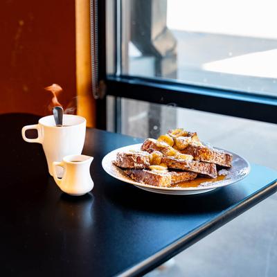 Elvis Toast served with syrup, topped with bananas and powdered sugar, coffee.