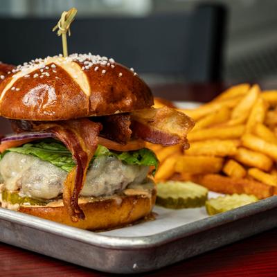 The US Open Burger with cheese, lettuce, tomato, onion, bacon and a side of fries.