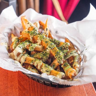 A basket of Furikake fries topped with sauce and seasoning.