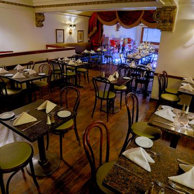Restaurant mezzanine with set tables and wall art.