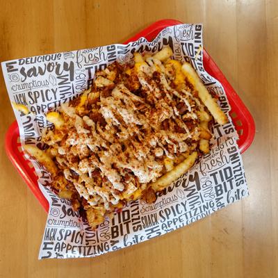 Loaded fries, with shredded chicken tenders, cheese, and sauce.