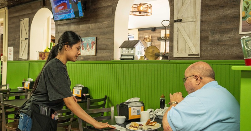 A server interacting with a customer in a dining setting