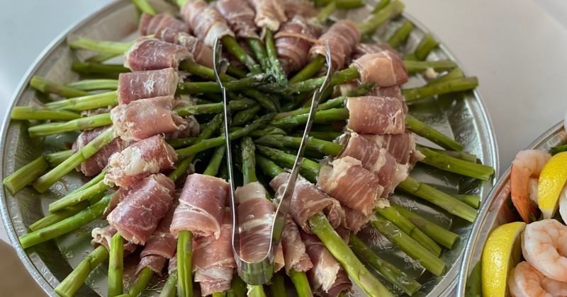 Prosciutto-wrapped asparagus appetizer arranged on a large platter