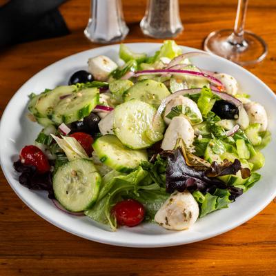Salad with lettuce, cucumber, grape tomatoes, red onion, black olives, and mozzarella.
