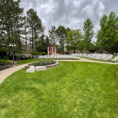 Lawn space with a wedding venue pavilion and white seats for wedding attendees