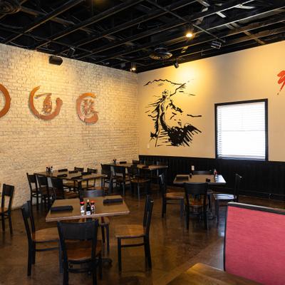 Dining room featuring white brick walls with Asian-inspired circular motifs.
