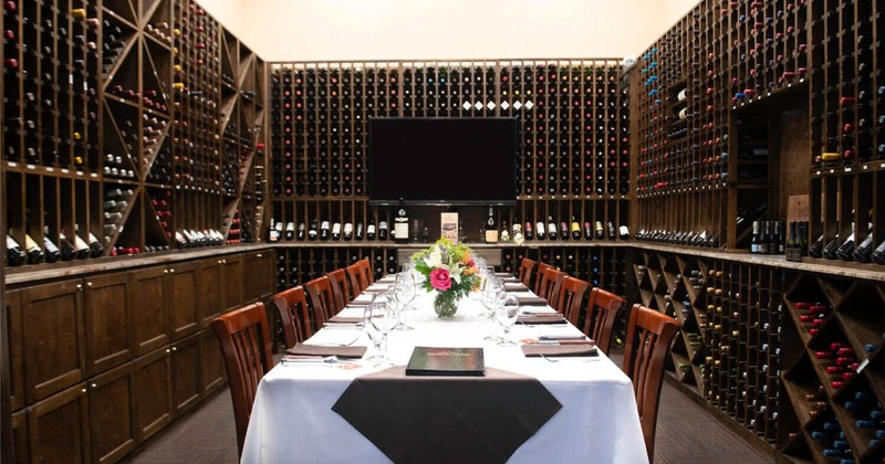 Interior, a long table ready for guests, large wine racks