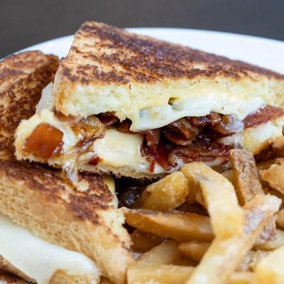 The triple threat grilled cheese sandwich served with french fries.