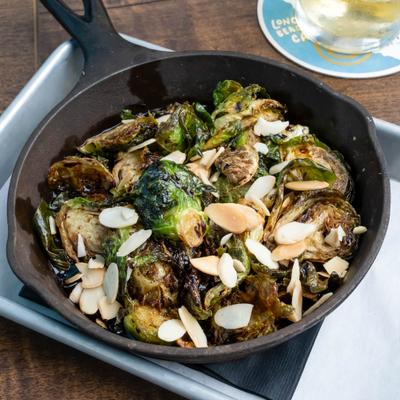 A dish of crispy Brussels sprouts served in a cast-iron skillet.