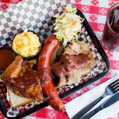 Sausage, chicken and pork with BBQ sauce, served with salad, and mac and cheese.