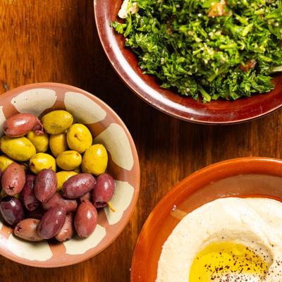 Tabouli, Baba Ghanoush, and a bowl with olives, top view.