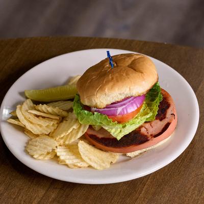 Bologna Sandwhich served with chips and a pickle spear.