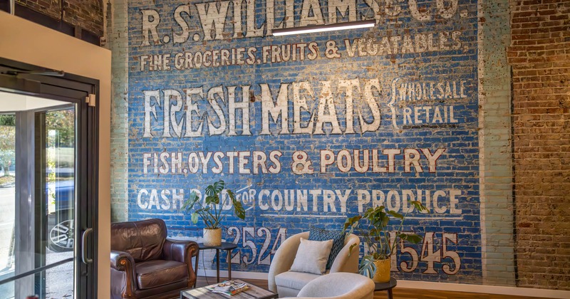 Interior, lounge seating by a brick wall with written text