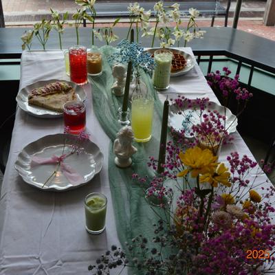 Food, drinks, and flower arrangements on the table.