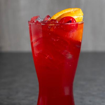 Blackberry Smash drink garnished with an orange slice and a cherry.