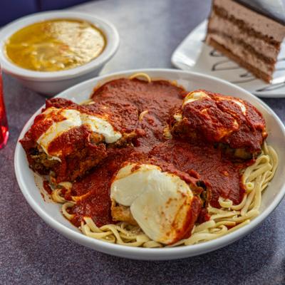 Stuffed eggplant with linguini served with other dishes.